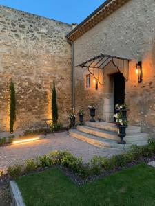 un edificio de piedra con una escalera que conduce a un patio en La Petite Aiguebonne, en Allex