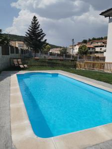 a large blue swimming pool in a yard at Hotel Rural Covarrubias in Covarrubias