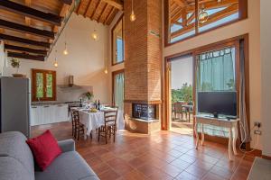 a living room with a couch and a tv at Agriturismo I Cerroni Montescudaio in Montescudaio