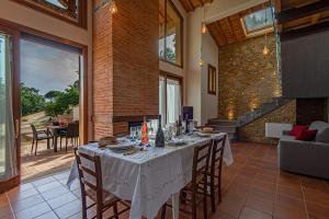 a dining room with a table with chairs and a couch at Agriturismo I Cerroni Montescudaio in Montescudaio