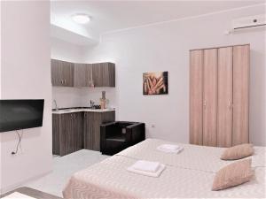 una stanza bianca con un letto e una cucina di Atrijum apartmani Apatin a Apatin