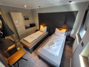 a small room with two beds and a desk at Liro Hotel Moers in Moers