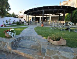 un patio con una pasarela de piedra, mesas y sillas en Maria's Studios, en Agios Georgios