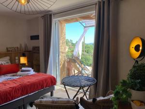 Cette chambre dispose d'un lit et d'une fenêtre avec vue. dans l'établissement Maison d'hôtes Une hirondelle en Provence, à Roussillon