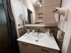La salle de bains est pourvue d'un lavabo blanc et d'un miroir. dans l'établissement La Vigna Dolce di Anna, à Florence