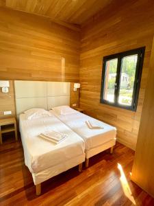 1 Schlafzimmer mit 2 Betten in einem Zimmer mit Fenster in der Unterkunft Résidence Les Pavillons du Golfe in Favone