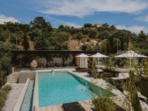 a pool with chairs and umbrellas next to a resort at Casa Costa Suites in Kanali