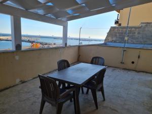 een tafel en stoelen op een balkon met uitzicht op de oceaan bij Casa Vacanze Preziosa in Mazara del Vallo