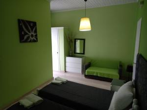 Sala de estar verde con cama y sofá en Maria's Studios, en Agios Georgios