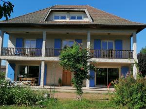 a large house with blue windows and a balcony at LOU GRAOU CHEPRE gîte d'étape in Chandon