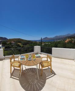 a patio with a table and chairs on a balcony at Orama Studios in Plakias