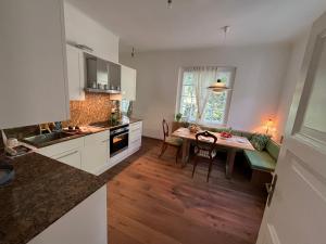 a kitchen with a table and a dining room at Landvilla im Park 
