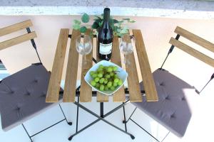 een tafel met een kom druiven en een fles wijn bij Cozy apartment with Free Parking & close to Lake in Lugano