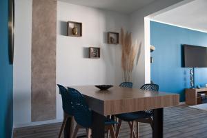 a dining room with a wooden table and chairs at Next to Disney Appart'Hôtel Le Rêve Bleu in Torcy