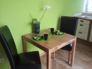 einem Holztisch mit zwei Platten und einer Vase mit einer Blume in der Unterkunft Mary´s Ferienwohnung in Kevelaer