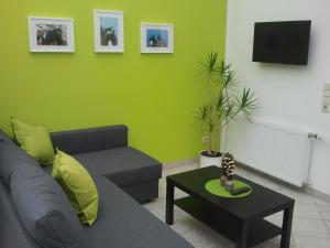 a living room with a couch and a green wall at Mary´s Ferienwohnung in Kevelaer