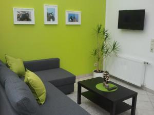 ein Wohnzimmer mit einem Sofa und einer grünen Wand in der Unterkunft Mary´s Ferienwohnung in Kevelaer