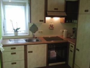 a kitchen with a sink and a stove and a window at Mary´s Ferienwohnung in Kevelaer