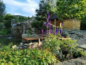 un giardino con laghetto, panca e fiori di Domek z widokiem a Sanok