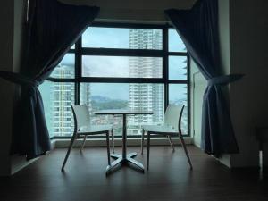 einen Tisch und zwei Stühle in einem Zimmer mit einem großen Fenster in der Unterkunft Private Jacuzzi Luxury Suite at KL City 178 in Kuala Lumpur
