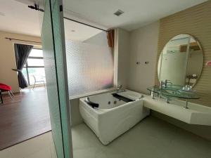 Private Jacuzzi Luxury Suite at KL City 178 في كوالالمبور: حمام مع حوض ومغسلة ومرآة