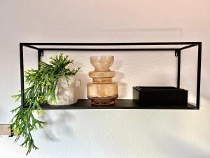 a black shelf with a vase and a plant on it at GALLERY APARTMENT: MAISONETTE + FREE PARKING + NETFLIX in Essen