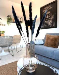 a vase with feathers on a table in a living room at GALLERY APARTMENT: MAISONETTE + FREE PARKING + NETFLIX in Essen