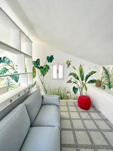 un salon avec un canapé bleu et des plantes sur le mur dans l'établissement Via Roma House Carloforte, à Carloforte