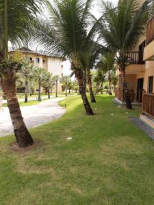 une rangée de palmiers dans une cour à côté d'un bâtiment dans l'établissement VG Sun Cumbuco Ce, à Caucaia