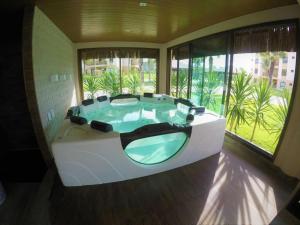 Cette chambre dispose d'une grande baignoire et de fenêtres. dans l'établissement VG Sun Cumbuco Ce, à Caucaia