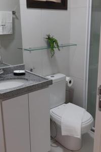 La salle de bains blanche est pourvue de toilettes et d'un lavabo. dans l'établissement VG Sun Cumbuco Ce, à Caucaia