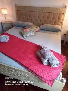 uma cama com um cobertor cor-de-rosa e duas luvas. em LA QUIETE TRA LE VIGNE Tuscany em Collesalvetti