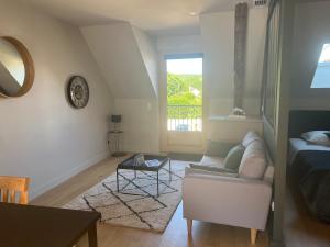 a living room with a couch and a window at Appartements Domaine Gueguen Chablis in Chablis