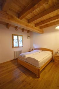 una camera con letto in una stanza con soffitti in legno di Chalet Brenta Dolomites a Madonna di Campiglio