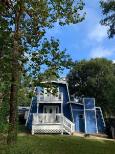 a blue house with a porch and a balcony at A-Frame in the Woods 