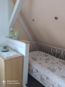 a small attic room with a bed and a staircase at Domizil der Sinne in Bad Liebenwerda