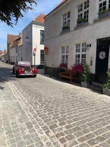 un coche rojo estacionado frente a un edificio en Guestsuite Lady Anna Bruges, en Brujas