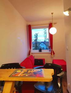 a living room with a table and a red couch at Moja Miłość. in Podgórzyn