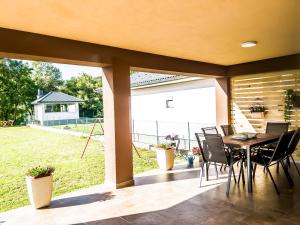 a dining room with a table and chairs on a patio at Daman Villa in Bihać