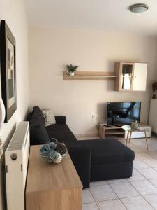 a living room with a black couch and a table at Nana Apartments in Perea