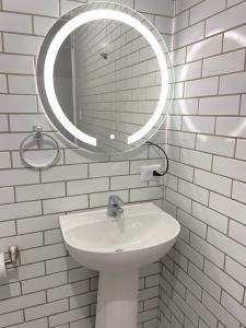 a white bathroom with a sink and a mirror at Hotel Hasta La Vista in Antigua Guatemala
