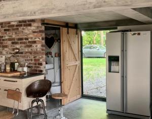 kuchnia z lodówką i ceglaną ścianą w obiekcie NATURE HOUSE Pszczyna w Pszczynie