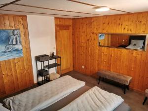een kamer met houten wanden, een bed en een spiegel bij Las aclas in Valbella