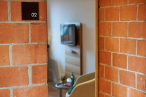 a brick wall with a tv on a wall at Parkhotel Wallberg in Volketswil