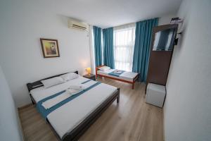 um quarto de hotel com uma cama e uma televisão em Holiday Park Verse em Ulcinj