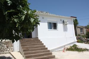una casa bianca con delle scale davanti di Condo Rentals a Sarandë