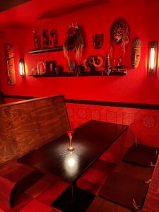 czerwony pokój ze stołem i czerwoną ścianą w obiekcie Insomnia Hotel w mieście Berga