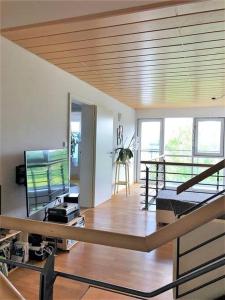 a living room with a staircase and a room with a television at Tolle große Wohnung mit Kamin und Terrasse in Weinstadt