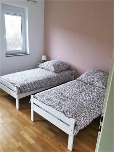 two twin beds in a room with a window at Tolle große Wohnung mit Kamin und Terrasse in Weinstadt