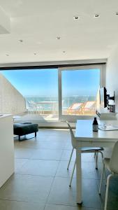 una sala de estar con una gran ventana con vistas al océano en DeHaanStudio, en De Haan
